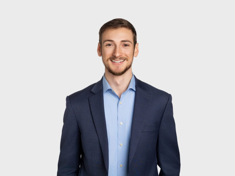 George Beinetti, a man with short brown hair wearing a dark blue jacket over a light blue shirt.