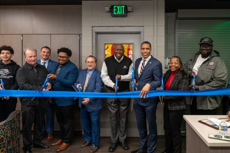 A group of people are gathered and posed to cut the ribbon for the new Teen Center at the Boys and Girls' Club headquarters in Rochester, NY.