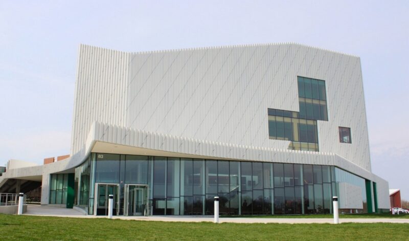 An exterior photo of the new RIT Performing Arts Center, a contemporary building with a "twisting" frame that represents progress.