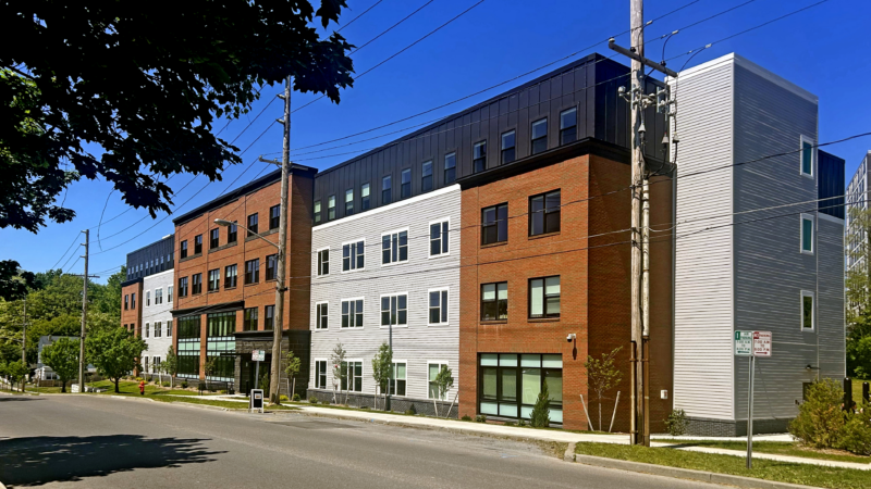 A photo of a brick building with white siding - it is the new Neighbors of Watertown affordable housing complex in Watertown, NY.